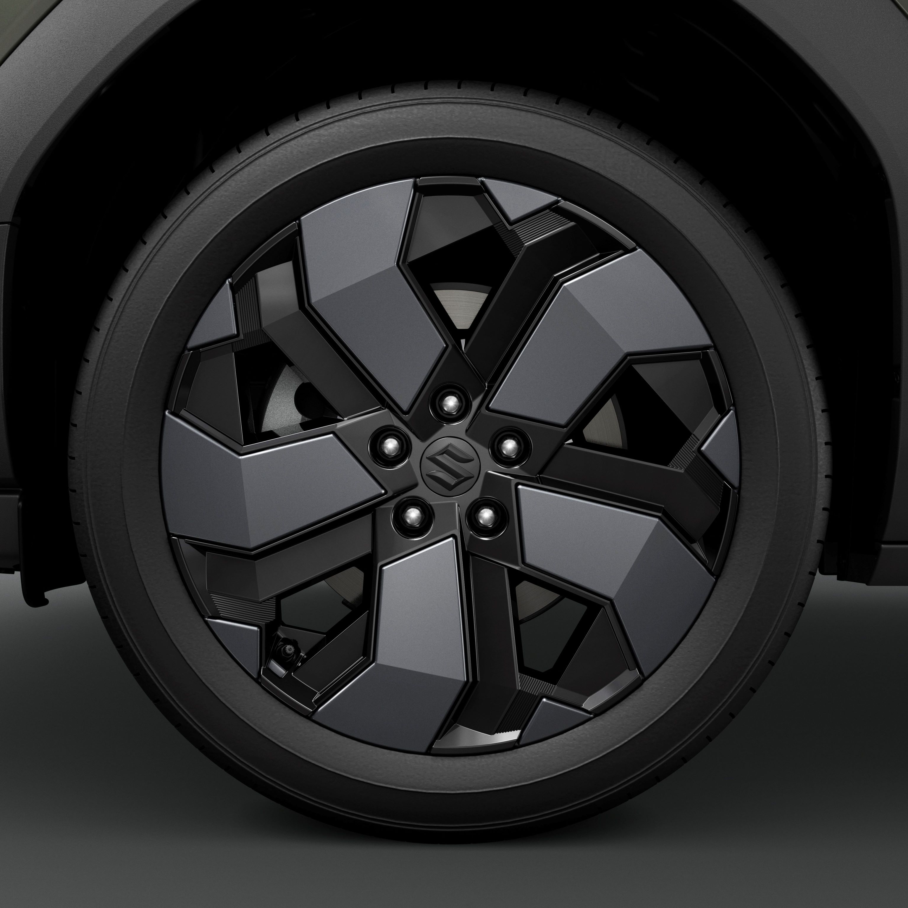 Close-up of a car wheel with a geometric black and grey rim design.