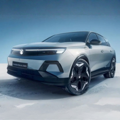 Silver electric SUV with logo, parked on a snowy surface.