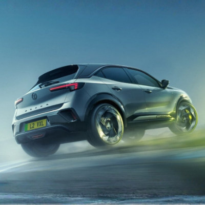 Silver SUV driving on a misty road, viewed from the rear and side.