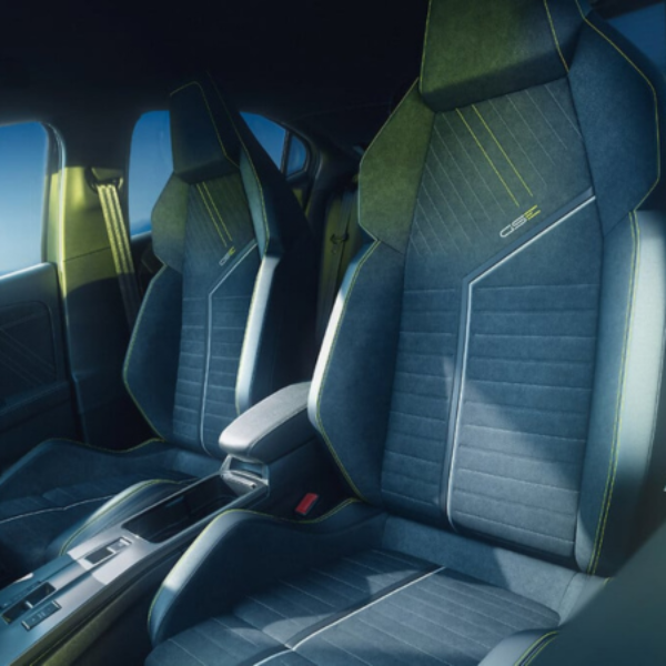 Car interior with two sporty front seats featuring neon green stitching.