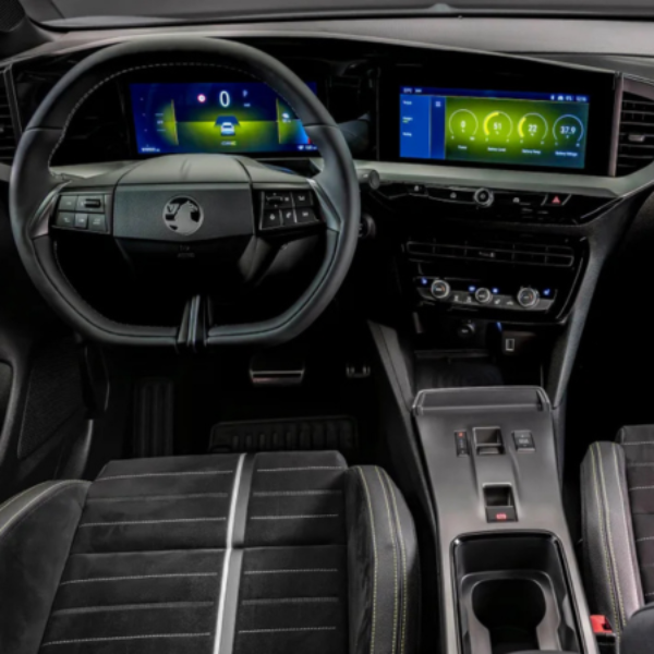 Car interior with digital dashboard, steering wheel, and touchscreen controls.