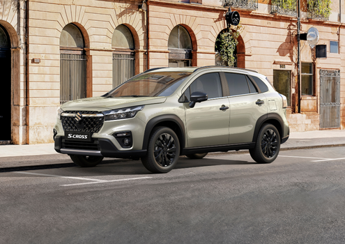 SUV parked on a city street with arched windows in the background.