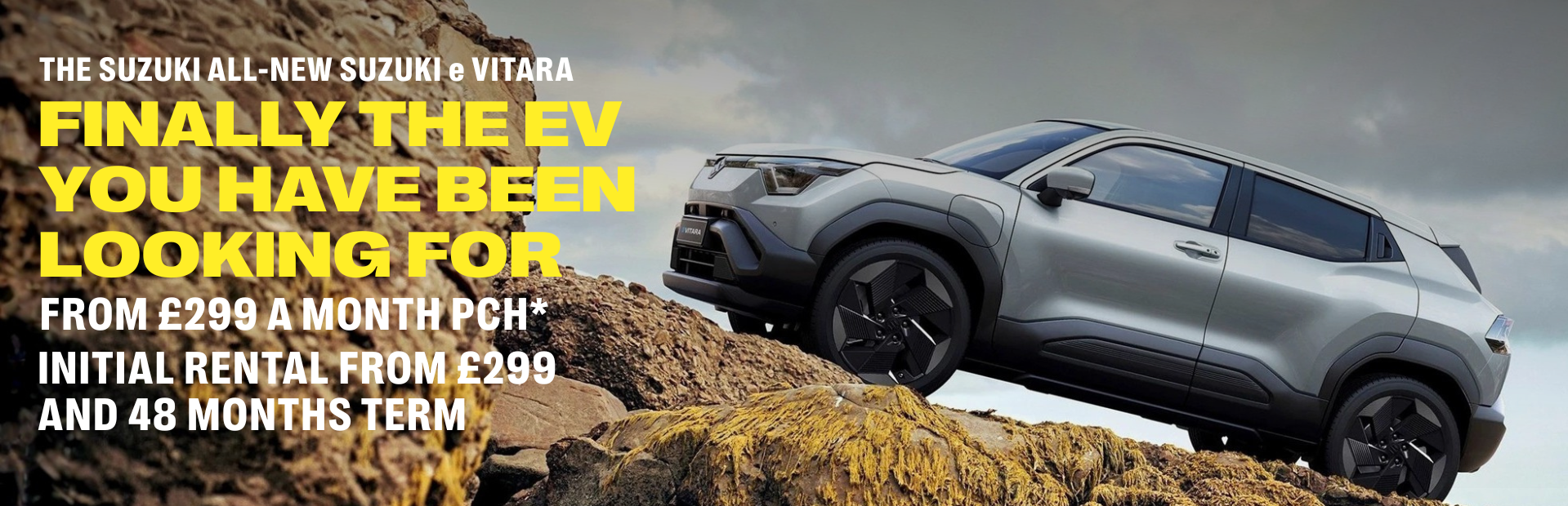 Silver SUV on rocky terrain with promotional text for the Suzuki e Vitara.